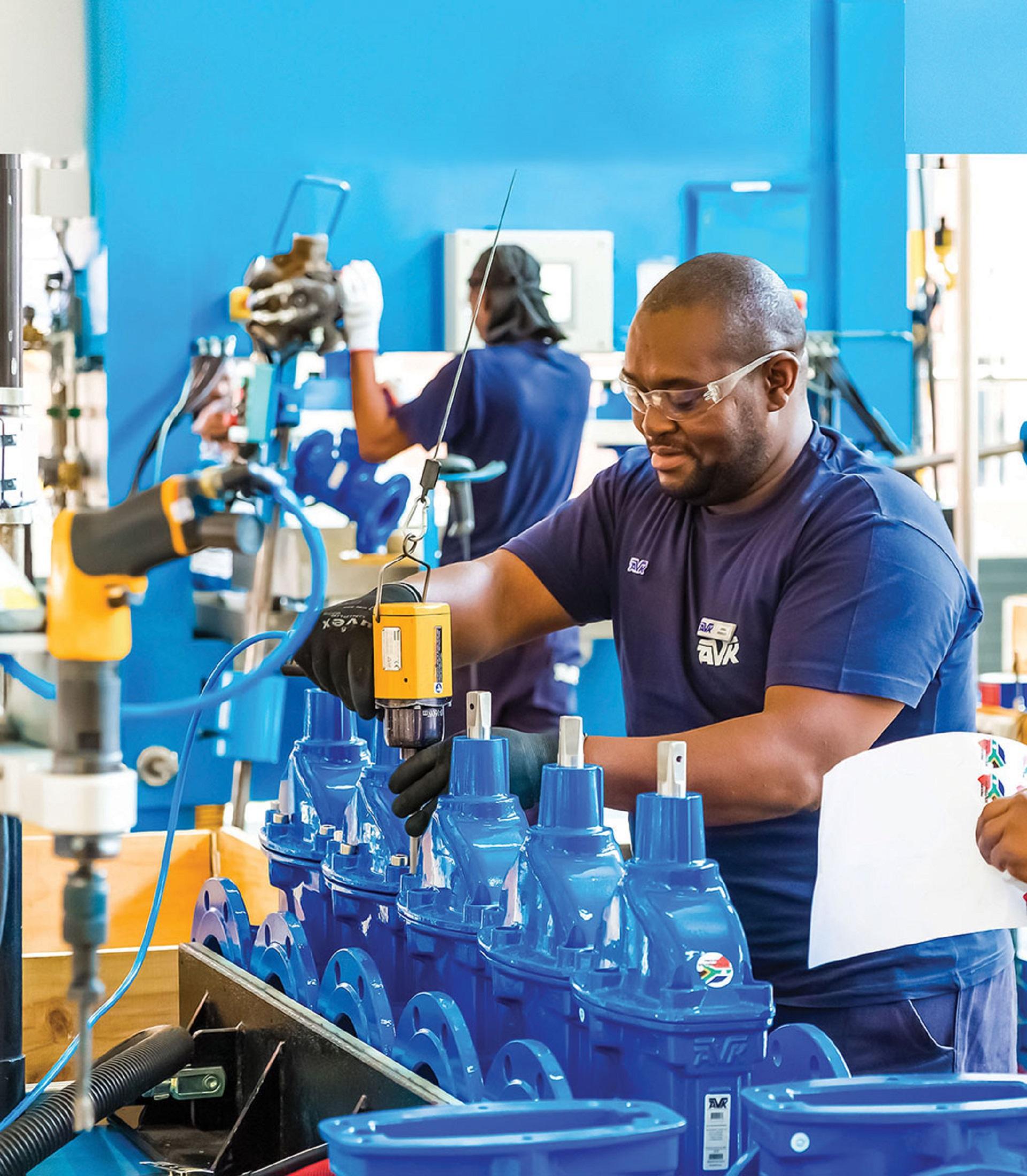 Worker operating industrial valve machine in a factory in Johannesburg, South Africa. Bigstock photo